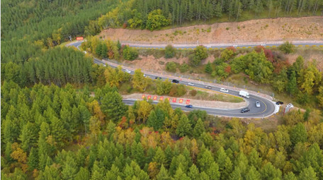 森林蜿蜒曲折公路旅行车流航拍