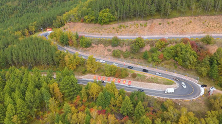 森林蜿蜒曲折公路旅行车流航拍