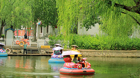 亲子乘坐游船小船泛舟湖上湖面杨柳实拍