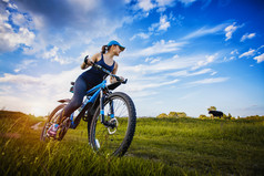 骑单车的女子在森林里骑一辆山地自行车.