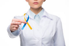 女医生持有蓝色和黄色丝带为唐综合症日隔离白色