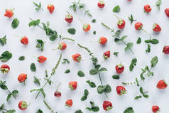 白色桌面上的薄荷叶新鲜草莓的顶级视图