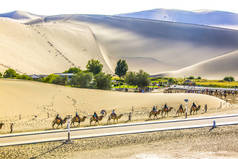 2018年9月17日, 在月牙湖 (岳岩) 戈壁沙漠和甘肃省西北部敦煌的歌唱沙山风景区骑骆驼的游客