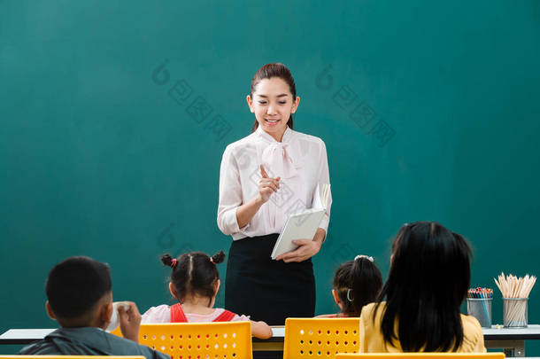 在课堂上, 亚洲老师站在全班同学面前教<strong>学生</strong>, <strong>学生们</strong>自觉地听她说话.