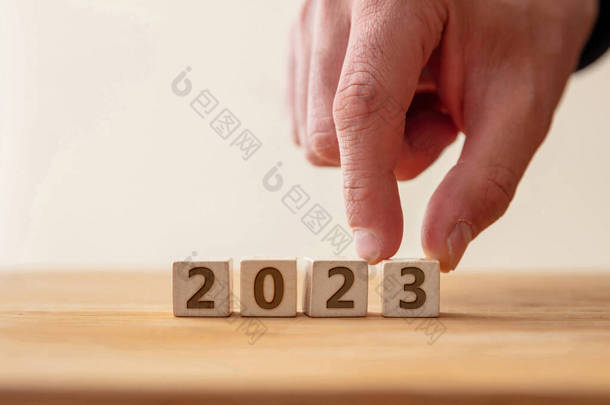 <strong>2023</strong>新年<strong>快乐</strong>庆祝理念。<strong>2023</strong>数字在木制立方体上与手指接触数字3 。新计划，商业，事业，目标，成功。问候语.