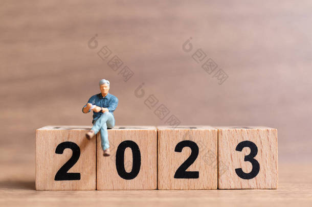 一个商人坐在2023号木块上。概念新年快乐