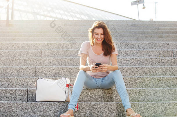 坐在台阶与智能<strong>手机</strong>上的女人