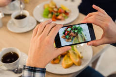 特写芒手考虑图片的食物与智能手机
