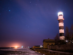 黑色和白色灯塔晚上在波罗的海海滩