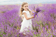 漂亮的小女孩在花篮薰衣草田