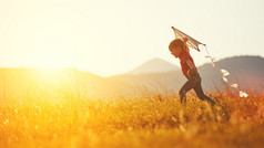 快乐的小女孩，夏天带着风筝在草地上奔跑