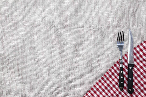 创建餐厅的菜单背景。亚麻桌布叉刀亮格仔布上。用于创建一个菜单，牛排餐厅.
