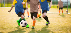 孩子们玩足球游戏锦标赛。孩子们的足球足球比赛。男孩跑和踢足球。在后台的青年足球教练