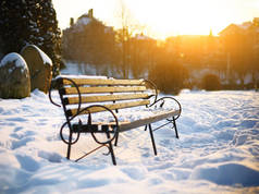 在冬季城市公园的长凳