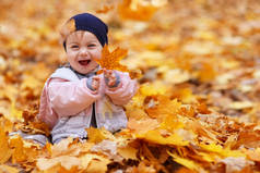 小女孩笑着，嬉戏着金色的落叶