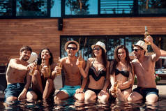 公司的年轻人有乐趣和享受夏季在水上乐园。游泳池派对暑假朋友一起在游泳池.