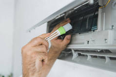 男性工人用刷子清洗空调器的裁剪视图