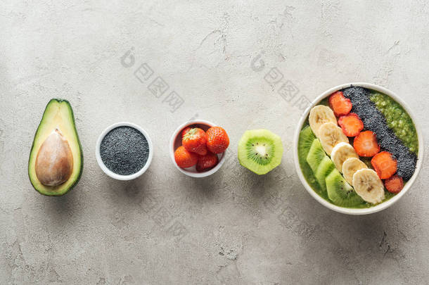 在灰色<strong>背景</strong>上的新鲜水果和<strong>食材</strong>健康的冰沙碗的顶部视图