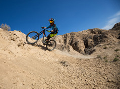 年轻男子在一辆山地自行车骑和轻松的在哈萨克斯坦恰伦大峡谷