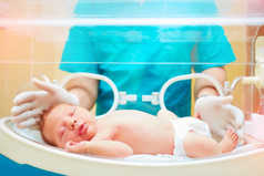 医护人员照顾刚出生的婴儿在婴儿培养箱