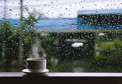 热饮料在下雨天的木桌上的杯子
