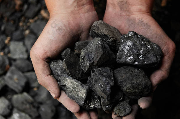 煤矿矿工在人手中的煤炭背景。煤炭开采或能源、<strong>环保</strong>。工业煤。火山岩.
