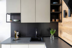 优雅的内饰概念。照片的黑色和白色现代厨房家具与架子和不同的东西在桌子上
