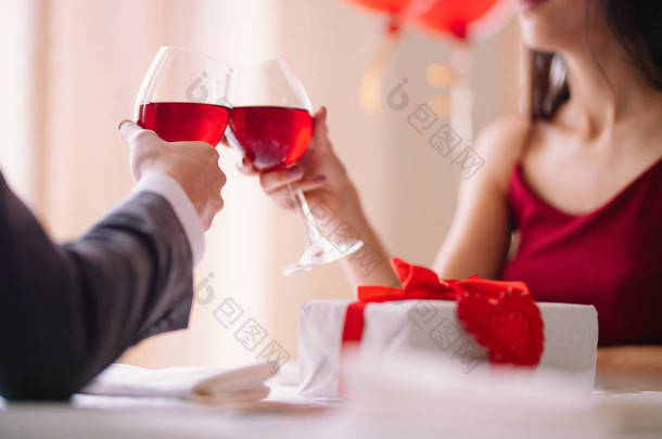 情人节的概念。幸福的情侣相爱。一对年轻恩爱的情侣在餐馆里庆祝情人节。恋人互赠礼物。情人节浪漫餐厅-概念.