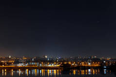 黑暗和宁静的城市景观与照明建筑和反映在河流在夜间