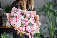 Pink peonies in womans hands. Beautiful peony flower for catalog or online store. Floral shop concep
