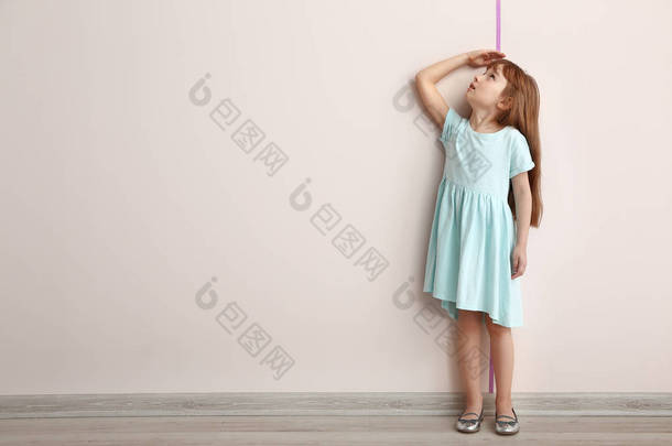 小女孩测量高度近墙