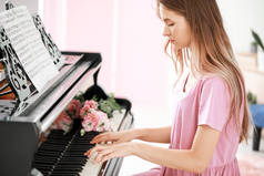 年轻女子在家里弹大钢琴