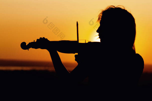 日落时弹奏小提琴的女性人物形象简介、自然表演、下巴下夹着乐器的女孩、概念音乐艺术