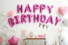 白墙上写着粉色气球信的生日快乐