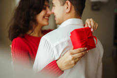 幸福的一对，抱着礼物。 手拿着礼物的一对快乐的夫妇彼此享受着. 情人节庆祝的概念。 关系、惊喜和爱情概念.