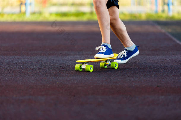 穿着蓝色运动鞋骑在<strong>活动</strong>的黄色滑板上,紧紧抓住腿. 积极的城市青年生活方式、培训、业余爱好、<strong>活动</strong>理念. 积极的儿童户外运动。 儿童滑板.