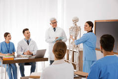 在课堂上学习人体骨骼解剖学的医学生和教授