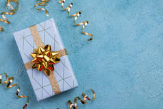 假日礼品盒用蓝色几何纸包裹,蓝色背景.节日快乐，圣诞快乐，生日快乐