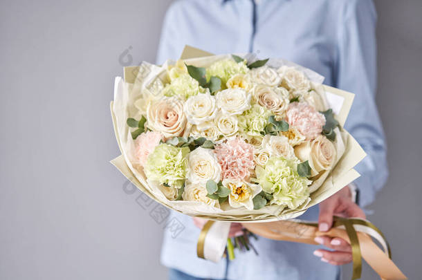 欧洲花店。女人手里拿着一束美丽的混合花.花店花商的工作。运送新鲜切花.
