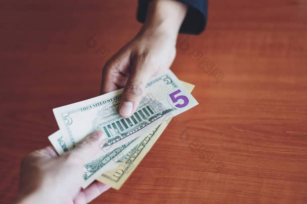 Business man give <strong>money</strong> bribe concept / person hands man giving <strong>money</strong> on wooden table background pay