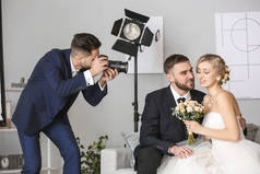 Photographer working with young wedding couple in studio