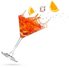 橘子和冰块掉进了一个被白色隔离的泼洒的马提尼酒中