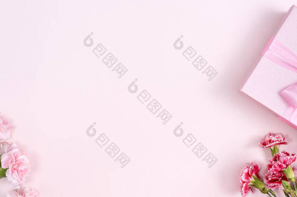母亲节，情人节背景设计理念，漂亮的粉色，粉色桌子上的红色康乃馨花束，顶视图，平铺，复制空间.