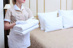 一个穿制服的女佣手里拿着洁白干净的毛巾.无法辨认的照片。酒店业务的概念。顶部视图.复制空间.
