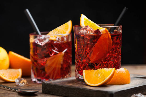 内哥罗尼鸡尾酒在水晶玻璃杯与橙片和新鲜的生橙子在切碎板上的木材背景过滤器。<strong>大佬</strong>