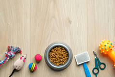 宠物护理和训练的概念。在木制桌子上摆满了干粮和猫狗饰品的碗。平躺在地上，尽收眼底。兽医商店的横幅模型.