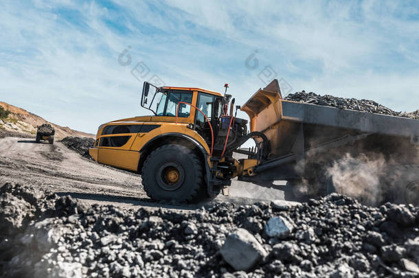 大型采石场垃圾车。把石头装到垃圾堆里.把煤装进货车里.生产有用矿物。采矿卡车采矿机械，从露天挖掘机运煤