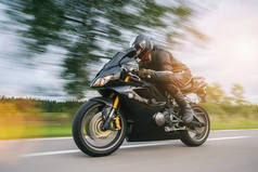 摩托车在路上以飞快的速度行驶。骑摩托车在空旷的路上行驶。个别文本的版权空间.