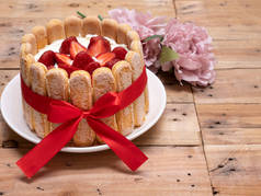 粗野木料背景上的草莓桂枝蛋糕.