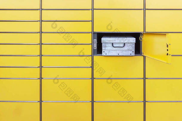 收到的包裹装在自动自助邮政终端机的开箱内。以黄色自动自助服务<strong>岗位</strong>终端装运。用开箱装包裹的邮筒墙壁的简约观点